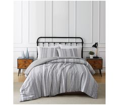 a black and white striped comforter set on a bed with two nightstands in the background