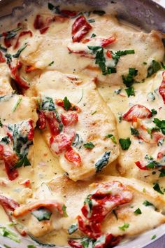 a pan filled with ravioli covered in cheese and spinach