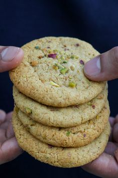 a person holding a stack of cookies in their hands