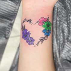 a heart shaped tattoo with flowers painted on the inside of it's middle arm