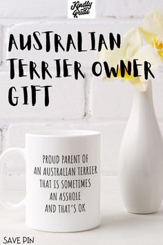 an australian terrier owner gift mug next to a white vase with a yellow flower