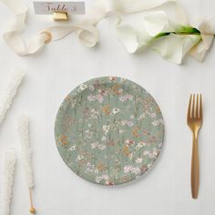 a place setting with flowers and goldware