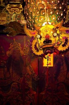 a chinese mask is lit up in the dark with colorful lights on it's face