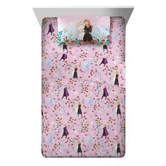 a pink bed with princesses and snowflakes on the sheet set is shown