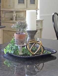 a candle and some plants on a tray