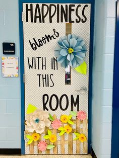 a door decorated with paper flowers and the words happiness is bloom's with in this room