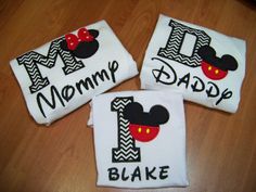 three personalized mickey mouse shirts on top of a wooden table