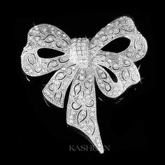 "PERFECT GIFT /WEDDING GIFT FOR BRIDE / GROOM / BRIDESMAID / LADY! Great Accent for your Wedding Dress! This sparkling Large Meticulous Bow Brooch made with tons of Swarovski crystals measuring 2 1/2\" wide X 2 5/8\" high (65mm X 68mm). Crystal Color: Crystal Clear Great piece for your collection! Prices are in US$. For shipping policies and other important information, click on \"profile\" on the right. See an item that you like but has already been sold? Contact me to see if I have more! Thank Silver Wedding Brooch With Ribbon, Formal Silver Brooch With Ribbon, Silver Bow Brooch For Wedding, Glamorous Rhinestone Wedding Brooches, Glamorous Wedding Jewelry With Bow, Silver Brooch With Decorative Bow For Evening, White Ribbon Brooch For Wedding, Silver Brooch With Decorative Bow For Party, Glamorous Silver Brooch For Wedding