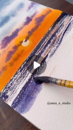 a paintbrush is sitting on top of a piece of paper that has been painted