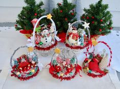 four baskets with christmas decorations on them sitting on a table