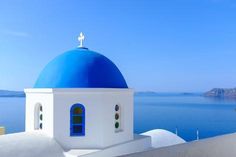 a white and blue building with a large body of water in the backround