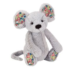 a gray teddy bear with flowers on it's ears and eyes, sitting in front of a white background