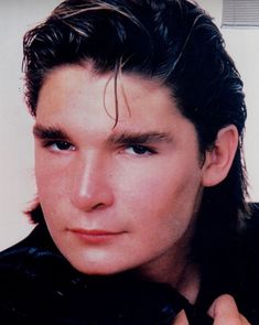 a close up of a person with long hair and wearing a black shirt, posing for a photo