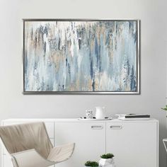 an abstract painting hangs on the wall above a white cabinet and chair in a modern living room