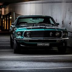 an old muscle car parked in a parking lot