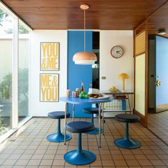 a blue table and four stools in a room