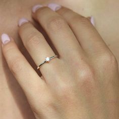 a woman's hand with a diamond ring on it