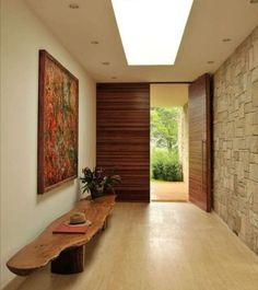 a wooden bench sitting in the middle of a hallway next to a wall with paintings on it