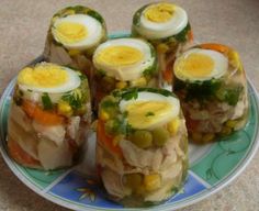 several sandwiches with boiled eggs and vegetables on a blue and white plate sitting on a table