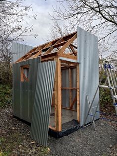 a metal shed is being built in the woods