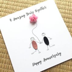 a happy anniversary card with an image of two people holding hands and a pink rose