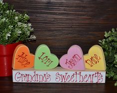 a wooden sign that says grandma's sweetheart on it next to a potted plant