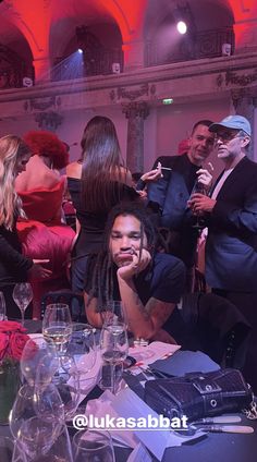 a group of people sitting around a table with wine glasses