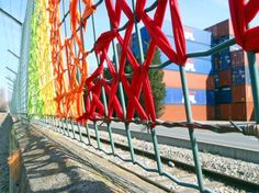 the red ribbon is hanging on the fence by the train tracks as it travels down the track