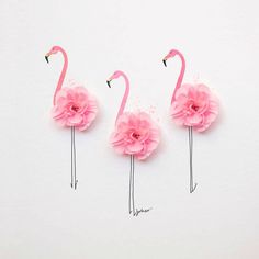 three pink flamingos with flowers on their legs