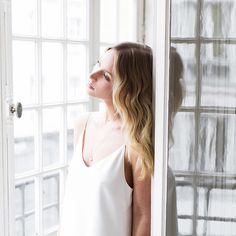 a woman standing in front of a window