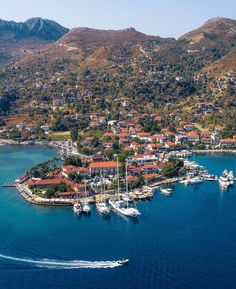 an aerial view of a small island with boats in the water and houses on it