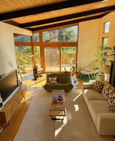 a living room filled with furniture and a flat screen tv on top of a wooden table