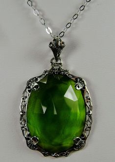 "Simulated Green Peridot Pendant Bubble Design#P10 Custom Made Inspired by Victorian era designs, I now offer this lovely Antique reproduction in sterling silver. The flawless simulated/man-made 22ct faceted green peridot gemstone is 24mm long (15/16th\") and 18mm in width (3/4th\"). The entire pendant is 1.5\" long and 7/8\" wide. The chain (if chosen) is between 18-20 inches in length and is marked 925 as well. Notice the beautiful craftsmanship of the Victorian filigree setting. This pendant Green Jeweled Necklaces For Anniversary, Green Jeweled Necklace For Anniversary, Green Oval Necklace For Wedding, Ornate Green Jewelry With Jewels, Classic Green Jeweled Necklace, Victorian Green Jewelry With Jewels, Elegant Green Filigree Jewelry, Ornate Green Jewelry For Formal Occasions, Victorian Green Jeweled Jewelry