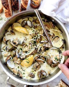 a pan filled with clams and lemons on top of a white countertop