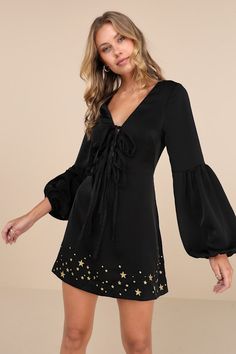 Put a twinkle in everyone's eye with a mysteriously sweet look like the Stoned Immaculate Wild One Black Star Embroidered Tie-Front Long Sleeve Mini Dress! Sleek satiny woven fabric shapes this too-cute dress with a flattering V-neckline, darted bodice with a tie-front design (with four tying bows), and long, seamed balloon sleeves with elasticized cuffs. The fit-and-flare silhouette finishes with an A-line skirt that boasts embroidered gold stars in varying sizes across the mini hem. Hidden bac Tying Bows, Dress With Flared Sleeves, Black Long Sleeve Mini Dress, Embroidered Tie, Black Embroidered Dress, Graduation Outfit, Wild One, Long Sleeve Mini, Black Star