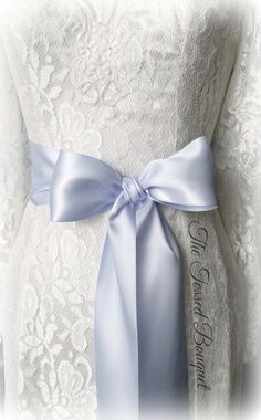 a white dress with a blue ribbon on it