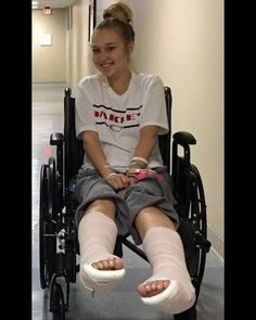 a woman sitting in a wheel chair with her legs wrapped around the leg support pads