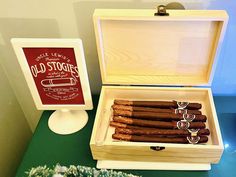 a wooden box filled with lots of different types of cigars on top of a table