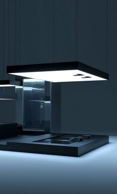 a modern kitchen with black cabinets and white lights on the counter top is illuminated by a square light fixture