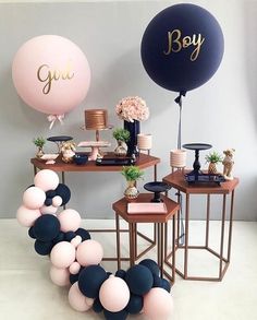 a table with balloons and other decorations on it, including a sign that says boy