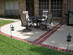 a patio with chairs and a grill on the side of it in front of a brick building