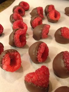 chocolate covered raspberries are arranged on a table