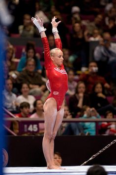 a woman in a red leotard doing gymnastics