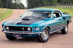 a blue mustang sitting on top of a parking lot