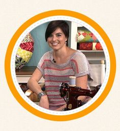 a woman smiling while sitting in front of a sewing machine with an orange circle around her