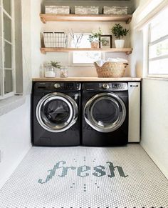 a washer and dryer in a small room with open shelving on the wall