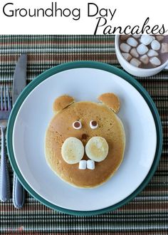 a plate topped with pancakes covered in marshmallows and a bear's face