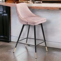 a pink velvet bar stool sitting in front of a counter