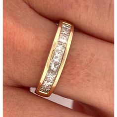 a woman's hand with a gold wedding band and diamond set in the middle