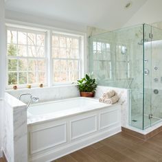 a bath tub sitting next to a window in a bathroom